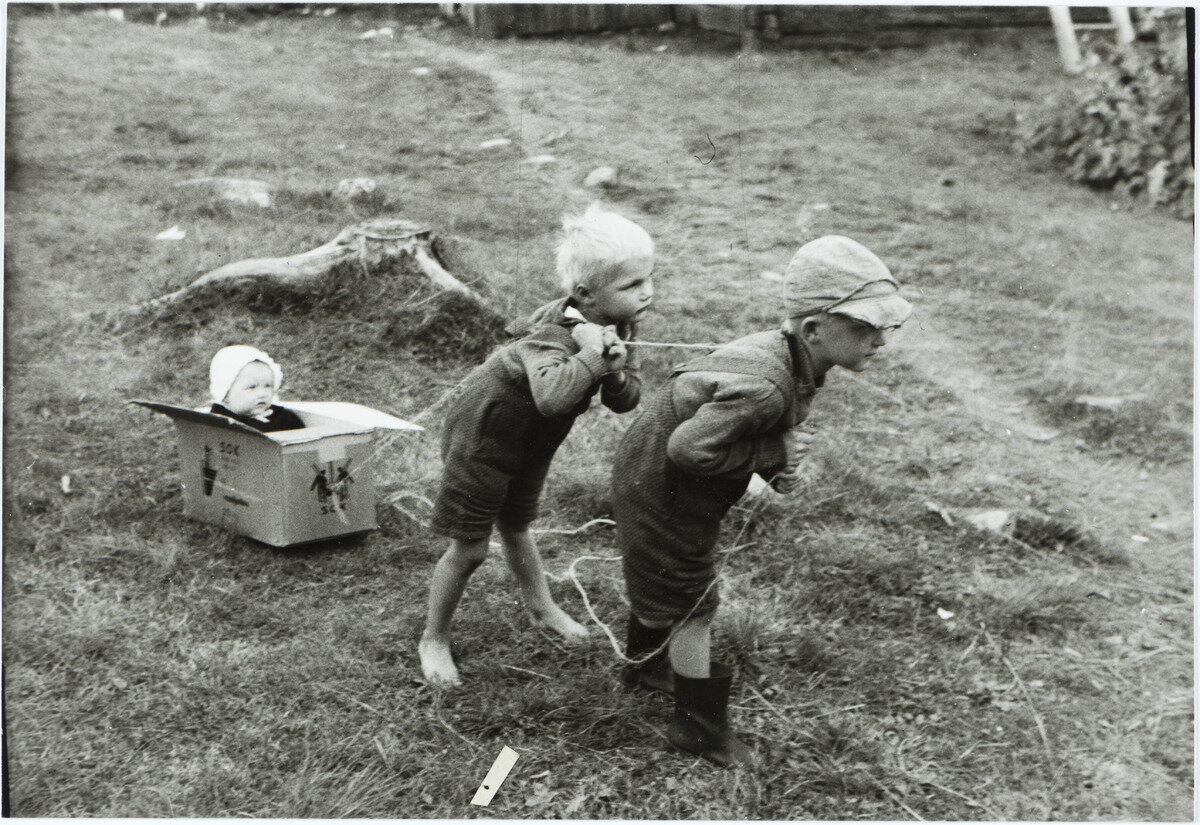 Valokuvassa maalaislapsuutta eletään Pielisjärvellä, vuonna 1935. Pojat vetävät naruilla hieman hämmentyneen oloista pikkutyttöä, mutta ainakin kuvan ottamisen hetkellä leikki sujui vielä hyvin. Kuva: Uuno Peltoniemi, Museovirasto.