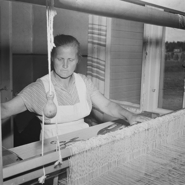 Kuva 2. Emäntä Siviä Kuparinen kutoo mattoa Suonenjoella 1953, kuvaaja Pekka Kyytinen, Museovirasto.
